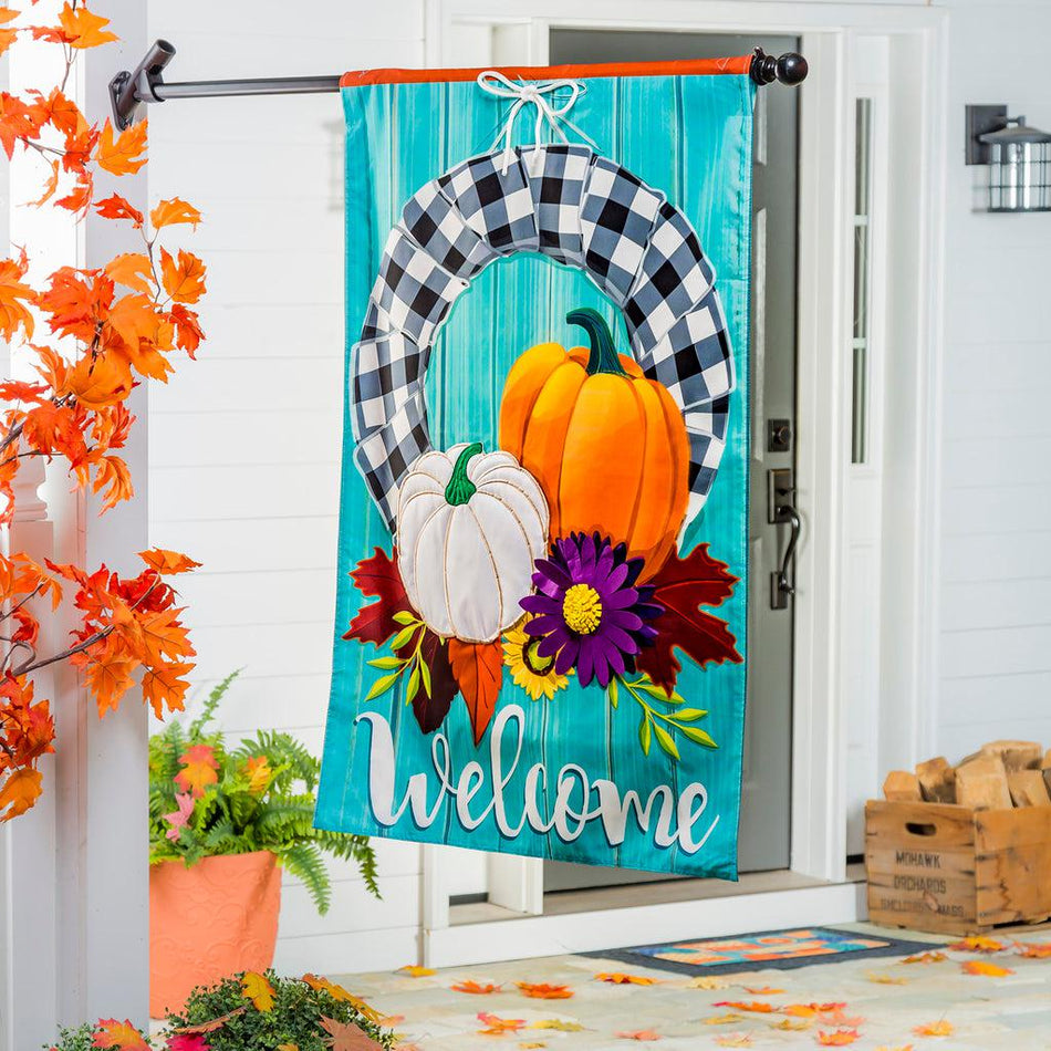 Our Buffalo Check Fall Wreath house banner features a black and white checked wreath decorated with pumpkin and flowers and the word "Welcome". 