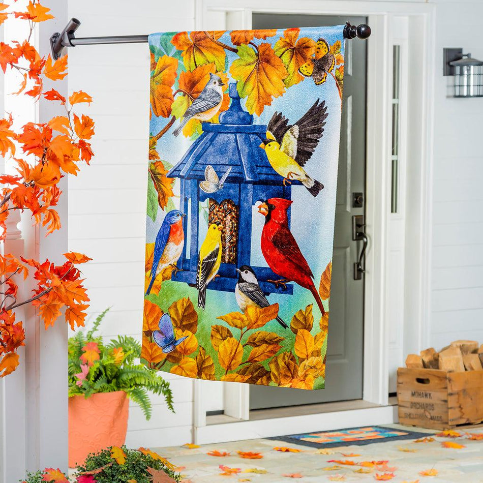 The Fall Feeder house banner features a multitude of birds feasting from a blue bird feeder surrounded by fall leaves.