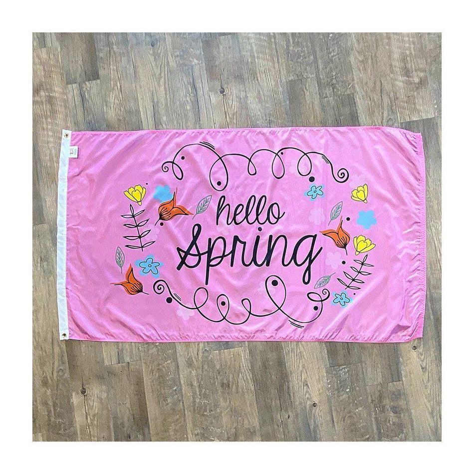 Our Hello Spring 3' x 5' Flag features whimsical flowers and "Hello Spring" message on a pink background.