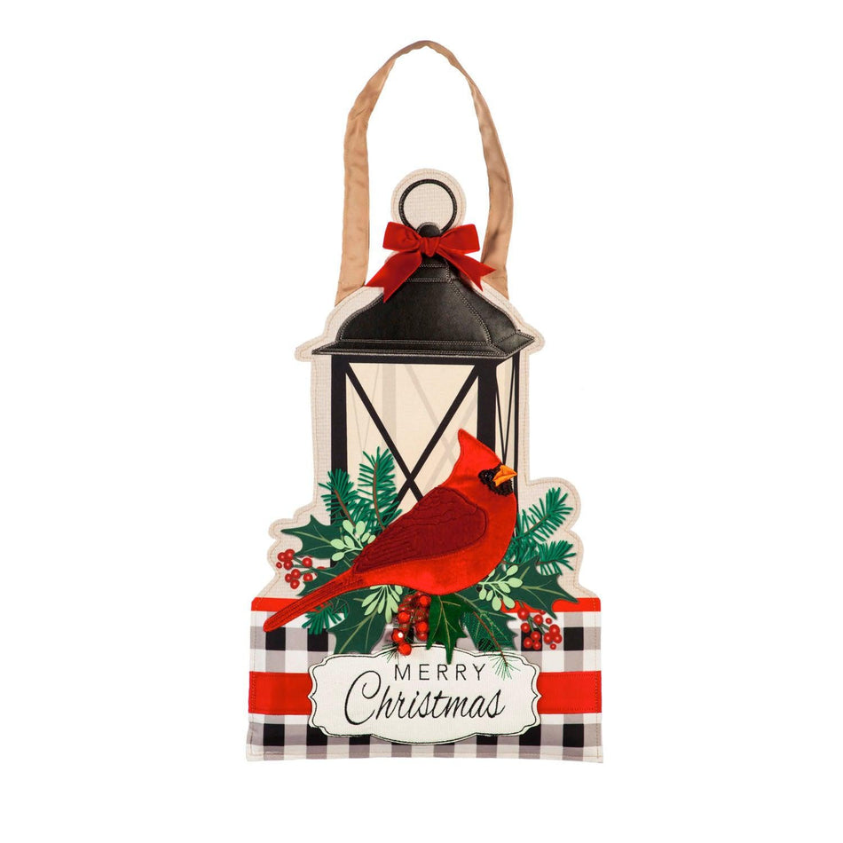 Our Merry Christmas Cardinal Door Décor features a cardinal sitting by a lantern and the words "Merry Christmas".