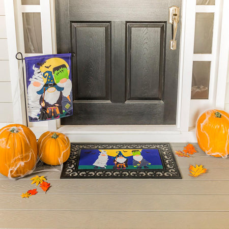 The Trick or Treat Gnomes garden flag features a trio of gnomes dressed in Halloween costumes and ready for trick or treating. 