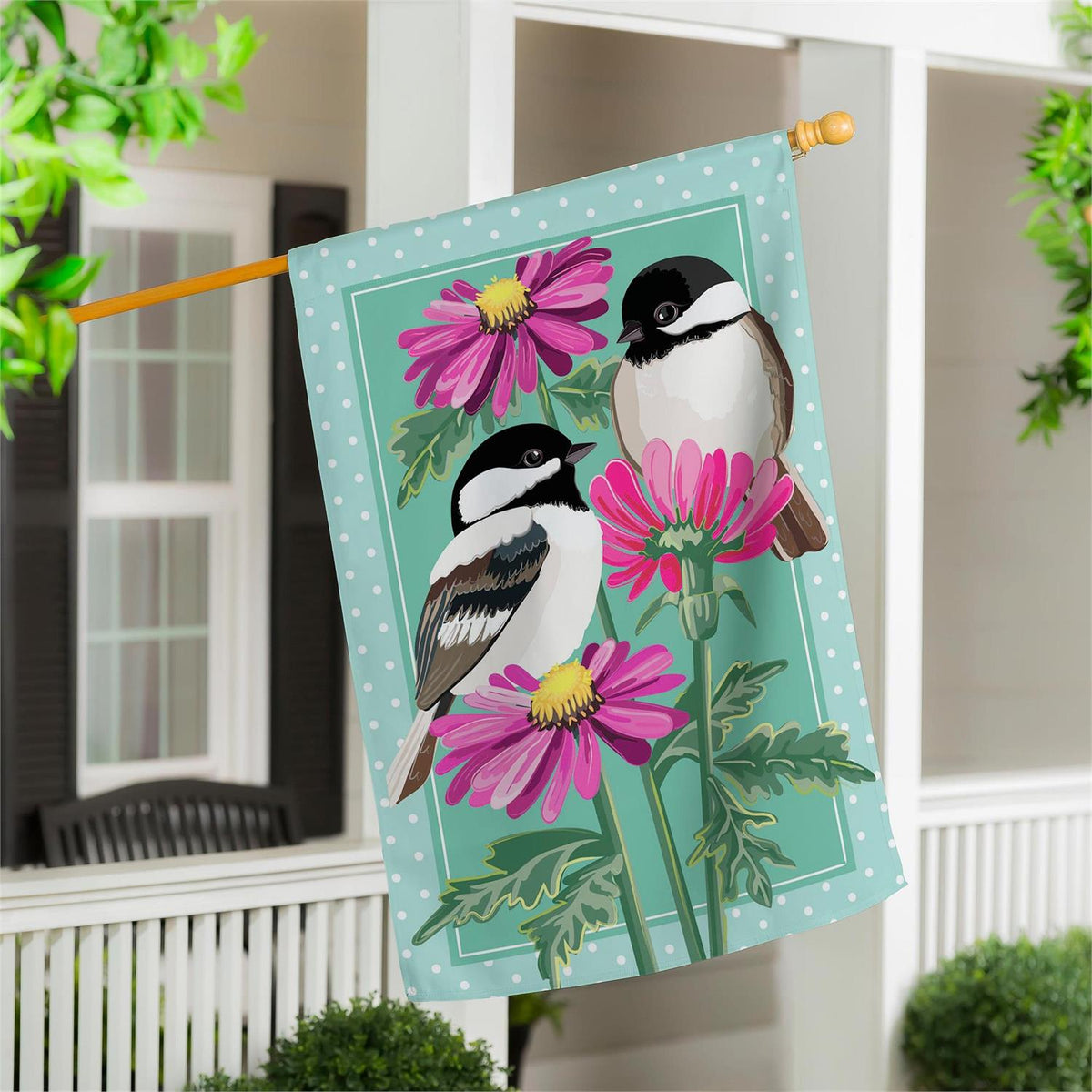 Decorative appliqued house flag with two chickadees and purple flowers on a teal background