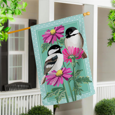 Decorative appliqued house flag with two chickadees and purple flowers on a teal background