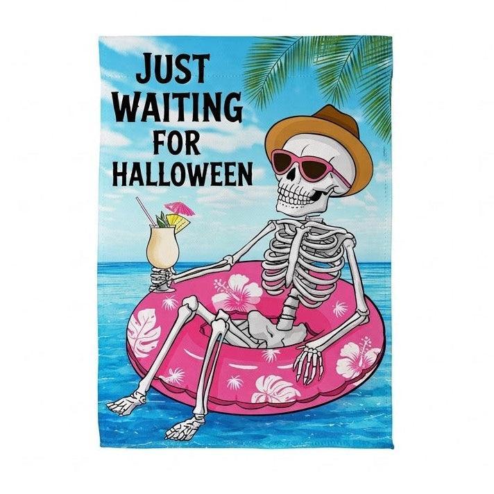 Just Waiting For Halloween Garden Flag Features a skeleton in a pink floatie in water with the words "just waiting for Halloween"