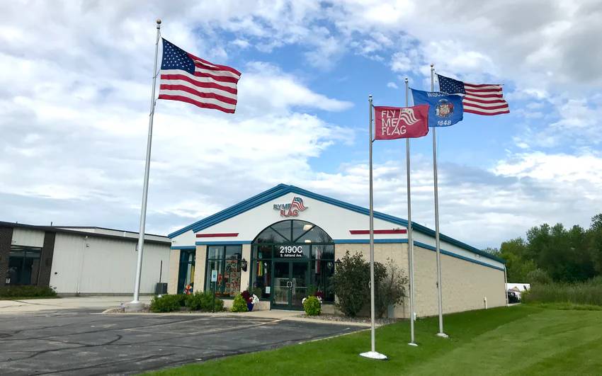 Flags flying on flagpoles outside the Fly Me Flag store in Green Bay, WI.