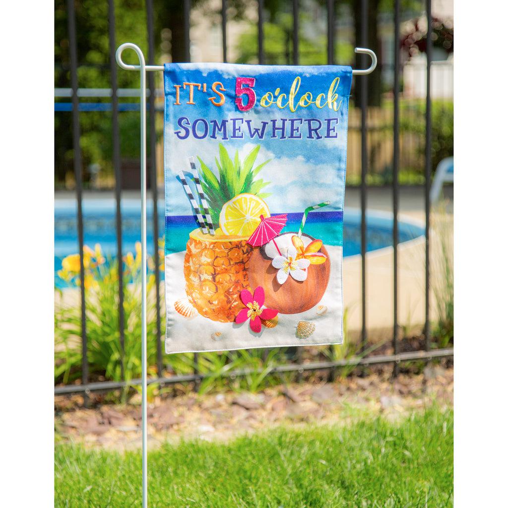 The 5 O'Clock Somewhere Beach garden flag features tropical drinks sitting in sand at the beach and the words "It's 5 O'Clock Somewhere". 
