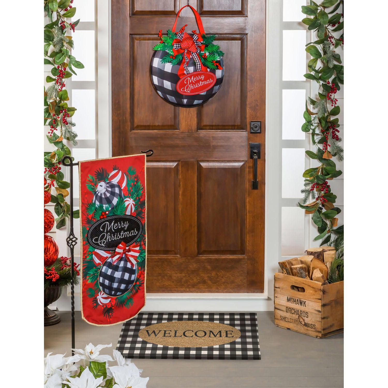 This extra-long garden flag features checked ornaments with candy and bows hanging on pine boughs and the words "Merry Christmas". 