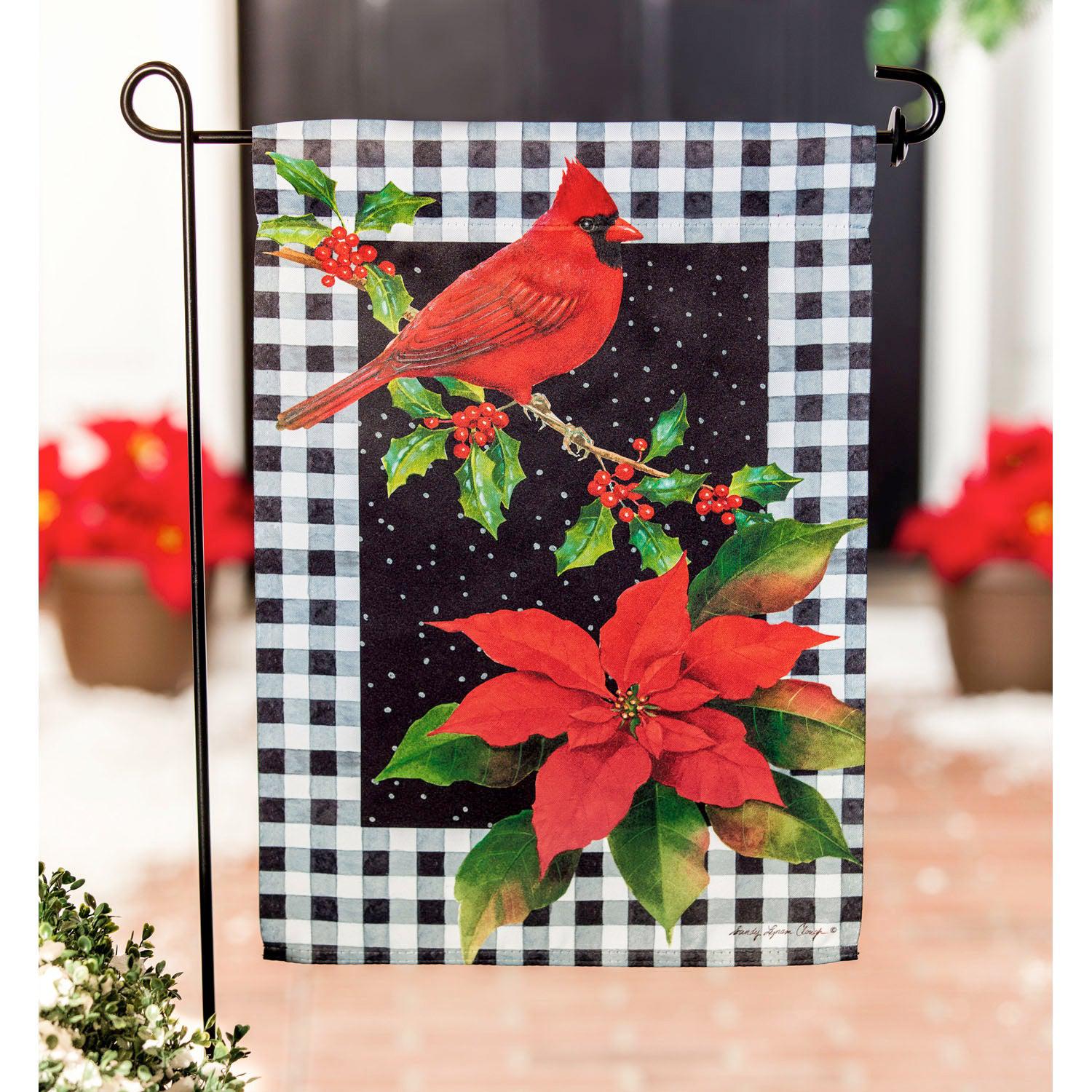 The Cardinal & Holly garden flag features a bright red cardinal sitting on a holly branch with a poinsettia in the lower corner and a black & white checked background