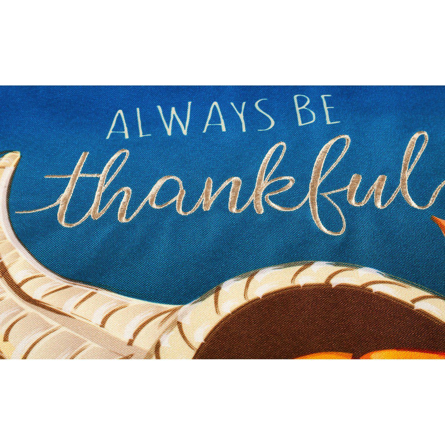 The Cornucopia With Checks garden flag features a cornucopia with fall fruits and vegetables and the words "Always Be Thankful". 