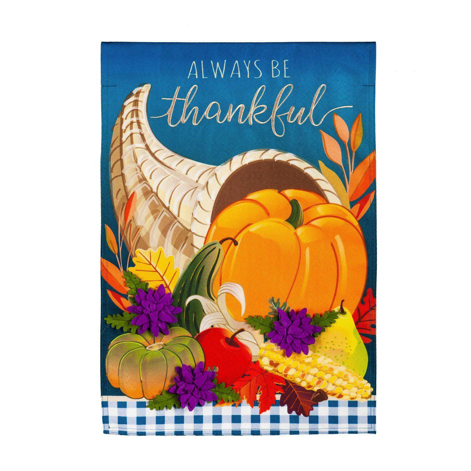 The Cornucopia With Checks garden flag features a cornucopia with fall fruits and vegetables and the words "Always Be Thankful". 