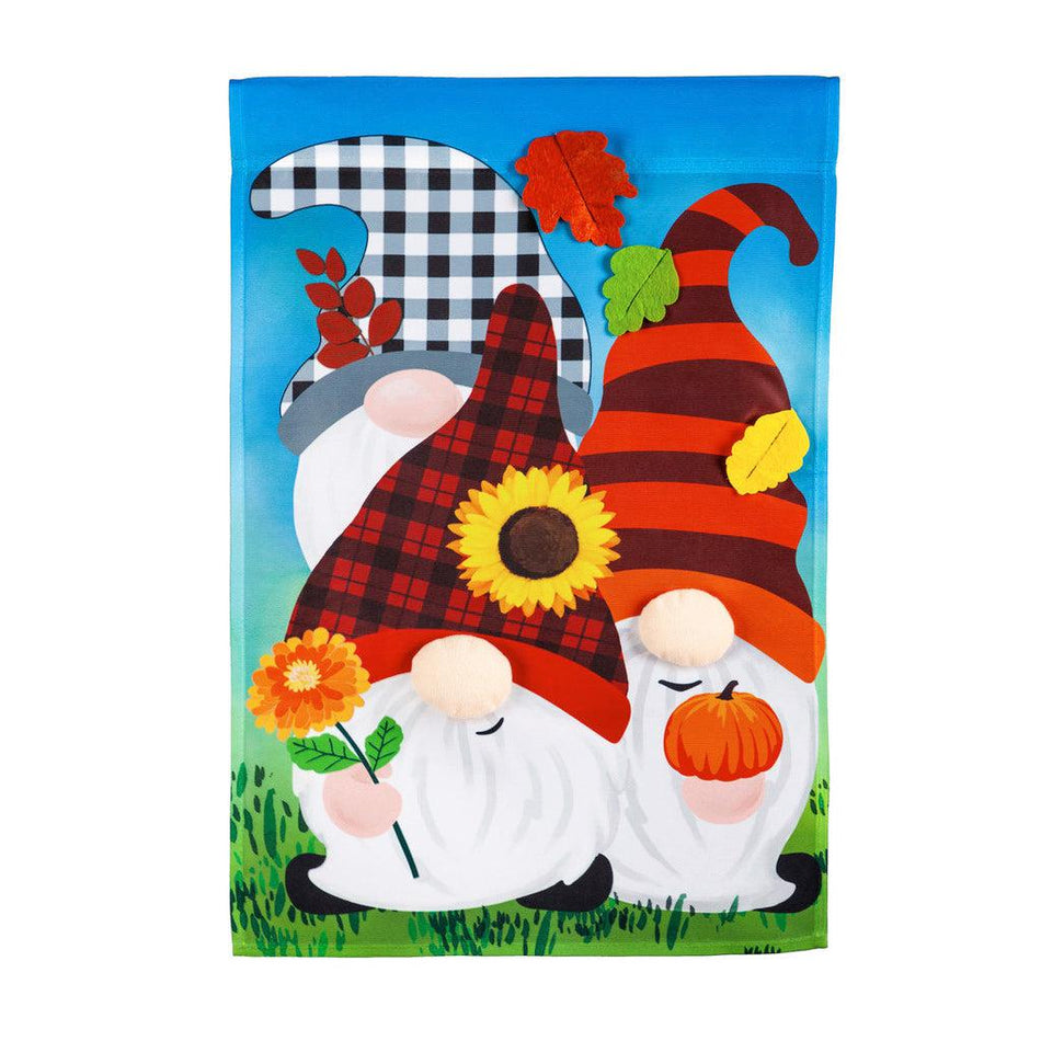 The Fall Gnome Trio garden flag features three gnomes with autumn inspired caps, flowers, and leaves. 