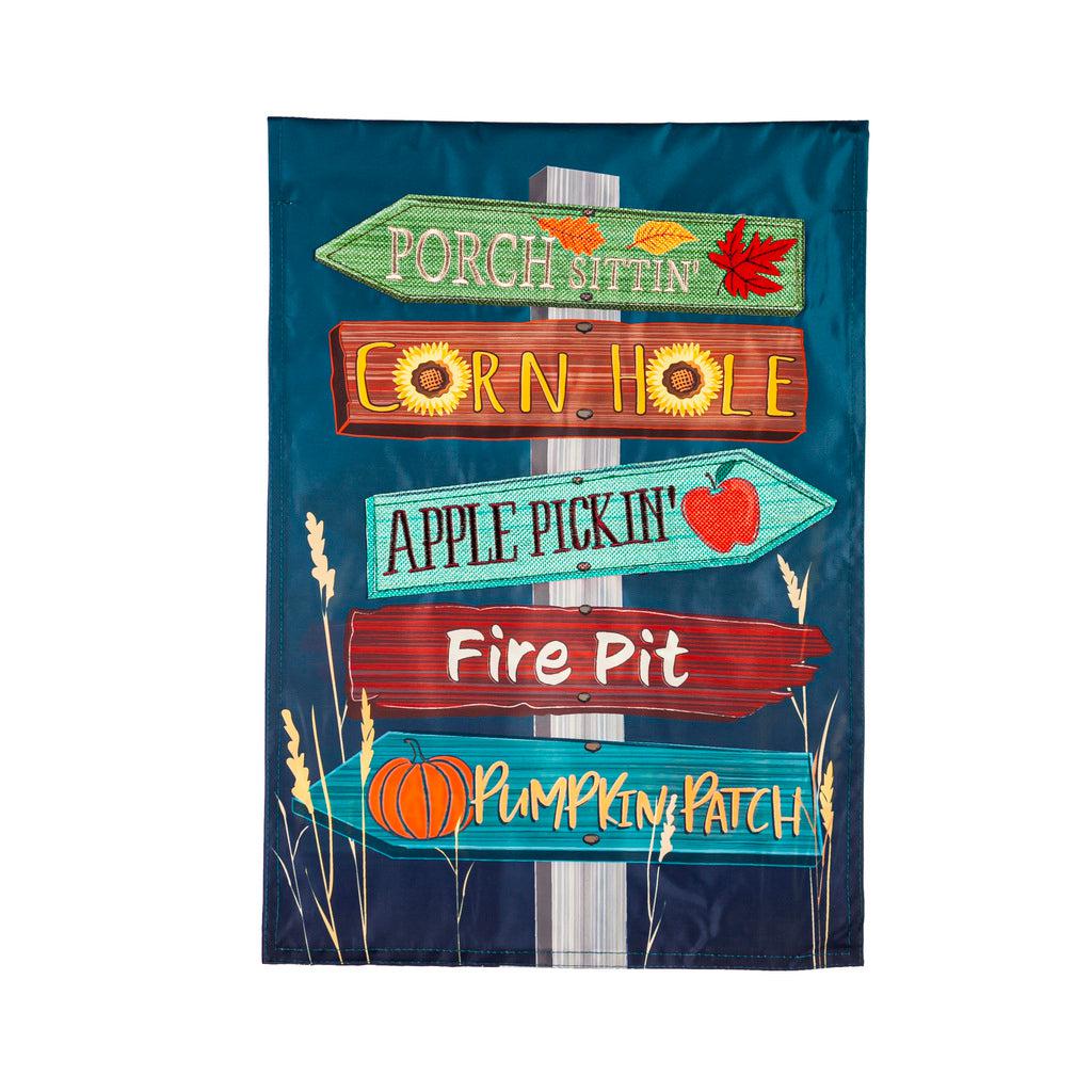 The Fall Signs garden flag features wooden arrows pointing in two different directions sending you to "Porch Sittin', Corn Hole, Apple Pickin', Fire Pit, and Pumpkin Patch". 