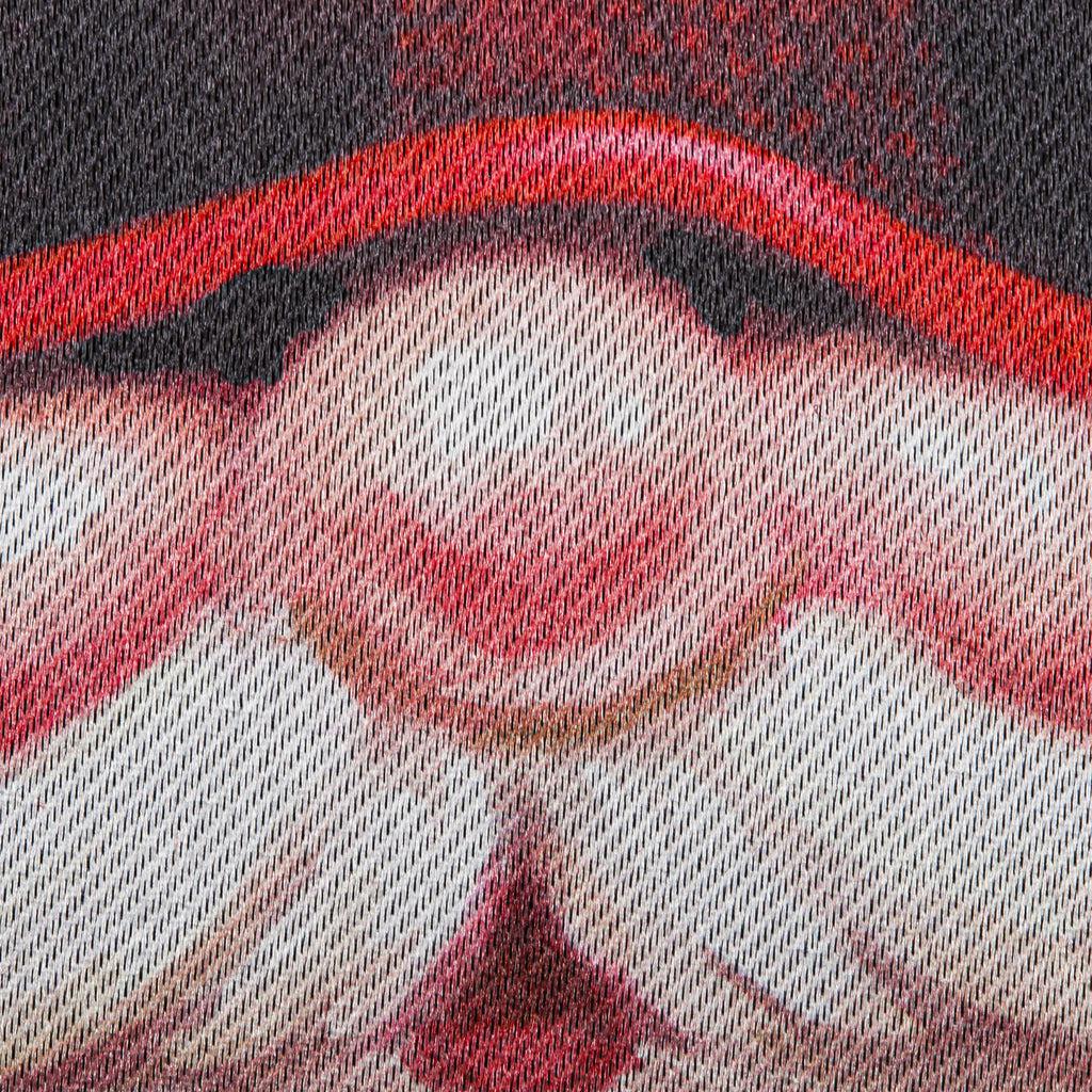 The Gnome With a Christmas Wreath garden flag features a smiling gnome sporting a pine wreath decorated in Christmas lights. 