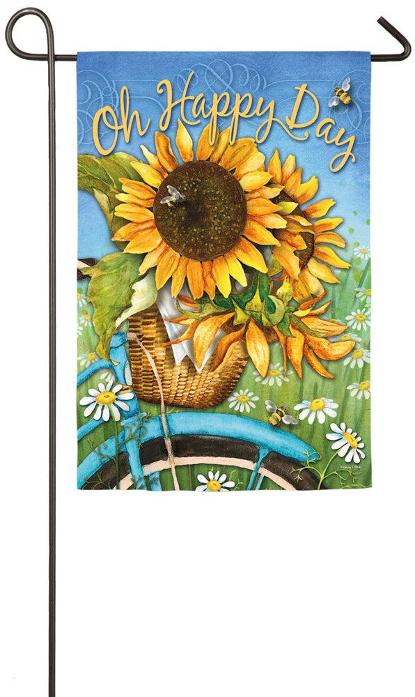 The Happy Day Sunflowers garden flag features sunflowers in a basket on the front of a bike and the words "Oh Happy Day". 