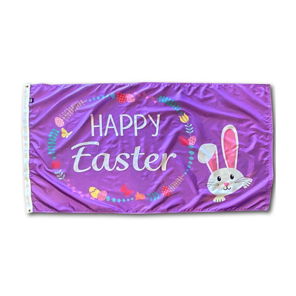 Our Happy Easter Wreath 3' x 5' flag features a cute bunny peeking out from the corner, eggs and flowers in a wreath design , and "Happy Easter" message on a purple background.