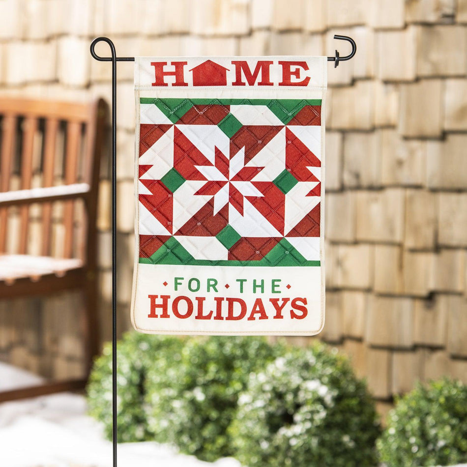 The Home for the Holidays quilted garden flag features a red, white, and green quilt design and the words "Home for the Holidays".