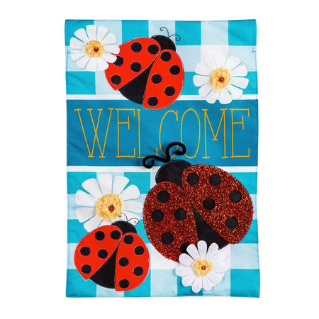 The Ladybug Plaid Welcome house banner features a trio of ladybugs on a bright blue checked background with white daisies and the word "Welcome". 