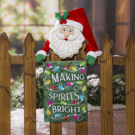 The Making Spirits Bright garden flag features a green pine needle background with a string of brightly colored Christmas lights.