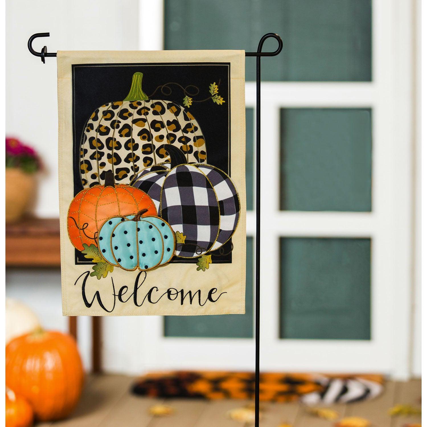 The Mixed Print Pumpkins garden flag features pumpkins in a variety of colors and patterns as well as the word "Welcome".