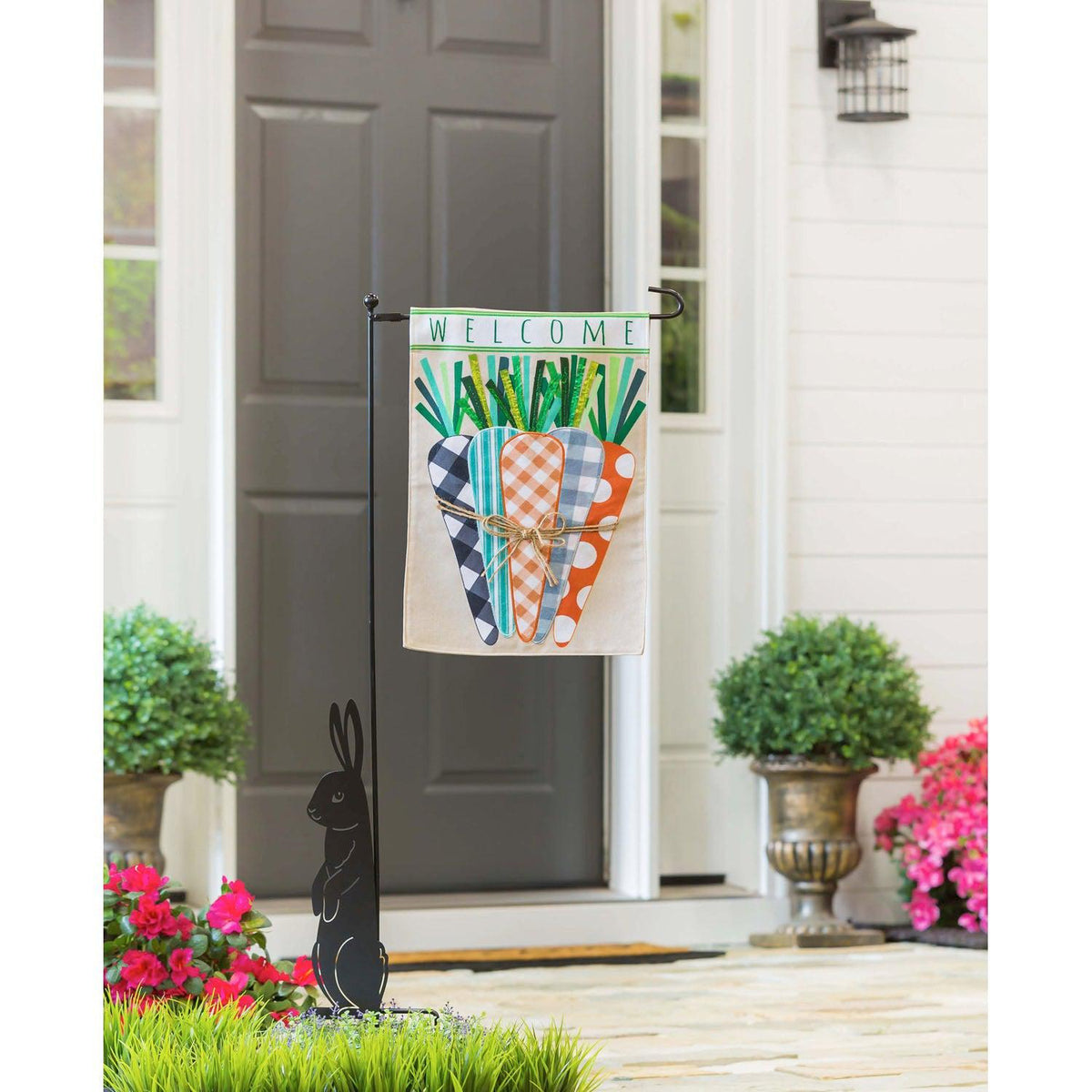 The Patterned Carrots garden flag features a bundle of multi-patterned carrots and the word "Welcome ". 
