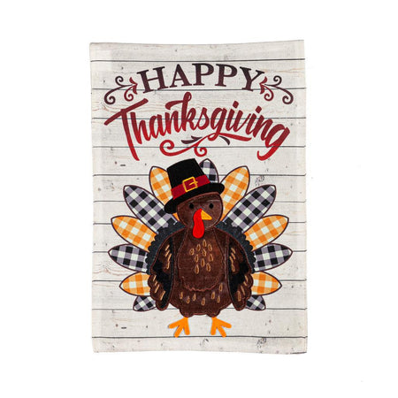 The Pilgrim Turkey garden flag features a turkey with a pilgrim hat, alternating gold and black checked tail feathers, and the words "Happy Thanksgiving". 