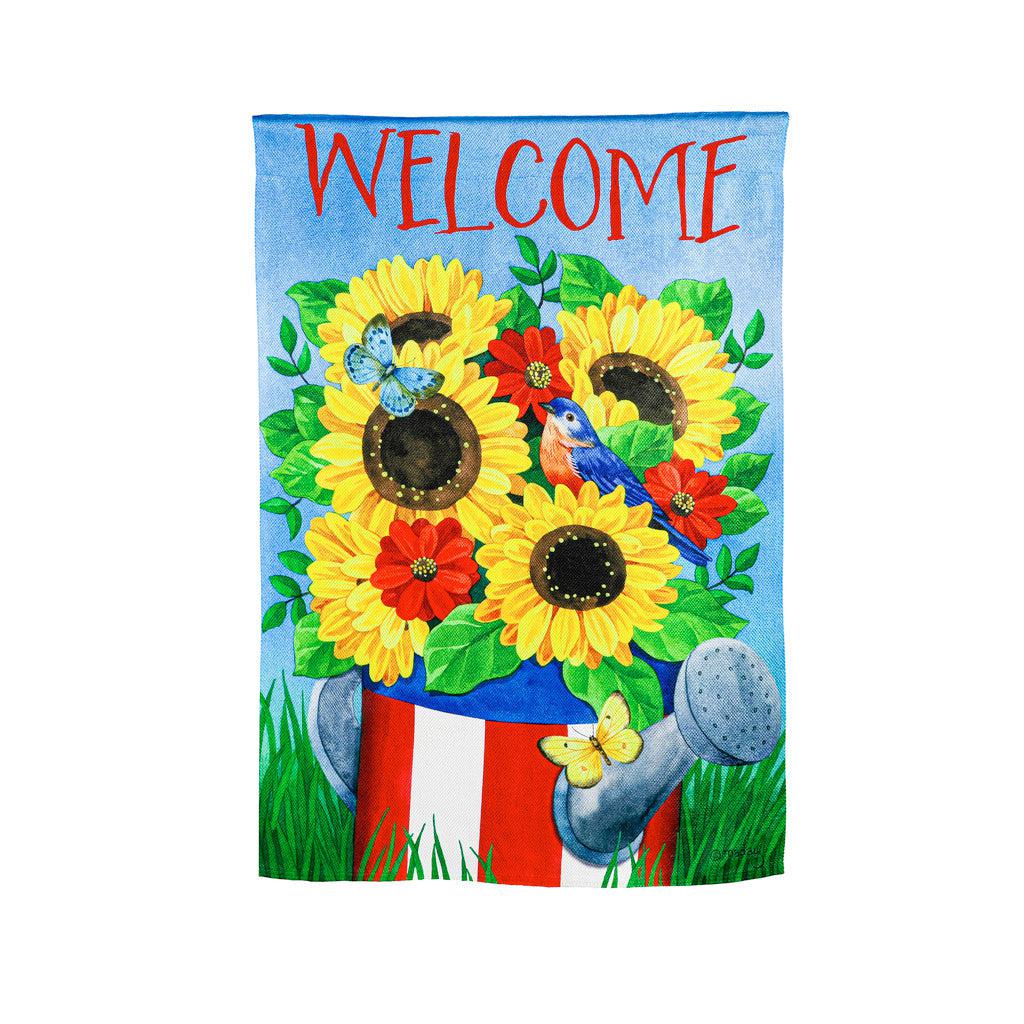 The Stars and Stripes Watering Can garden flag features bright yellow flowers in a patriotic watering can and the word "Welcome" across the top.