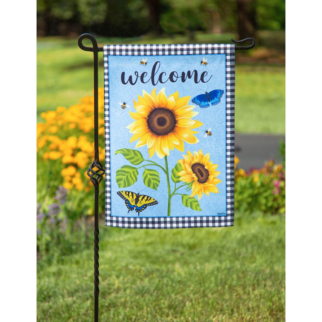 The Sunny Sunflower garden flag features bright yellow sunflowers over a sky blue background, a black checked border and the word "Welcome" across the top. 