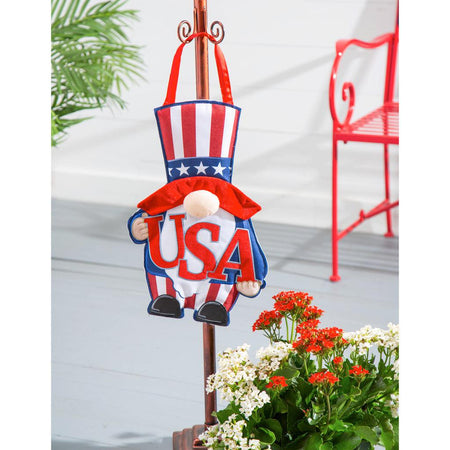 The USA Gnome door décor features a patriotic gnome dressed in stars and stripes and holding the letters USA. 