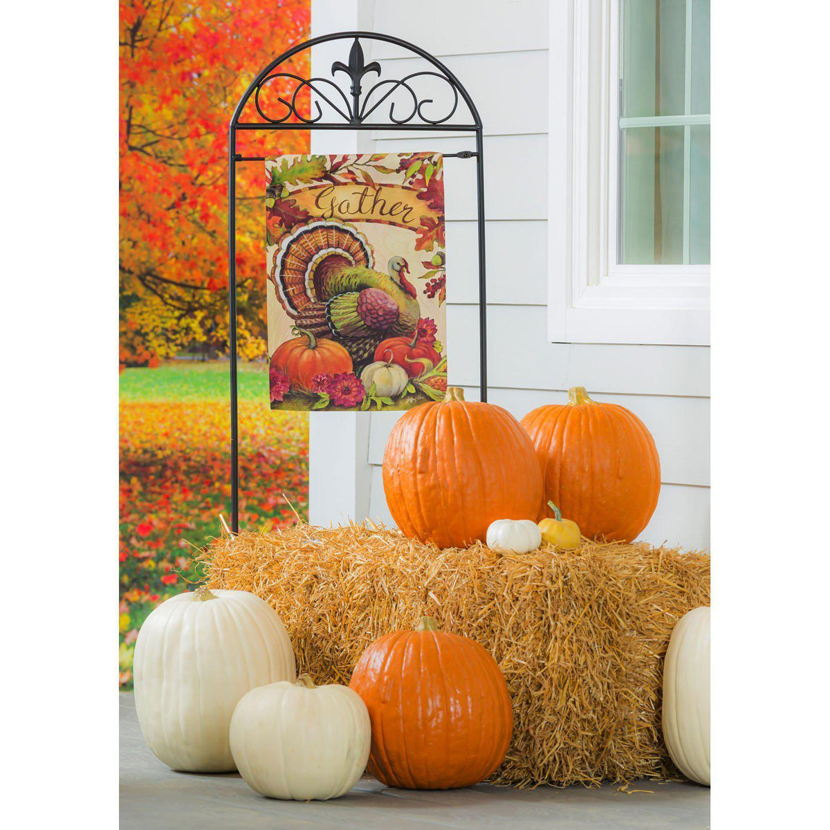 The Warm Gathering Turkey garden flag features a turkey resting among pumpkins and the word "Gather" surrounded by fall leaves. 