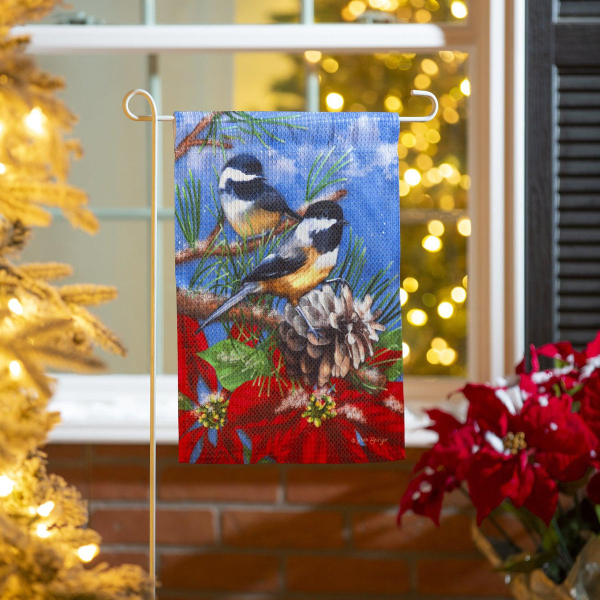 The Winter Chickadees garden flag features two chickadees with poinsettias and a pinecone. 